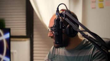Close-up of streamer man talking into microphone with other players during space shooter tournament. Online streaming cyber performing games competition using technology network wireless photo