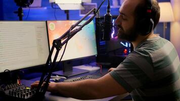 Professional digital player with headphones streaming game with modern graphics for shooter online game championship. Pro gamer playing digital game in gaming studio photo