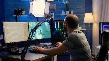 Streamer man sitting on gaming chair and start playing space shooter game during online tournament. Pro cyber talking into microphone with other players on streaming chat photo
