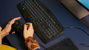 Closeup of wireless joystick and RGB keyboard, pro game r playing online games on powerful computer. Player using professional equipment during gaming online competition photo