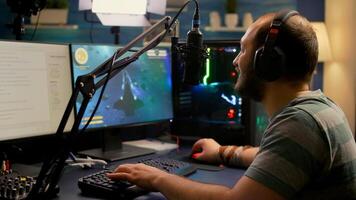 Streamer man wearing headset start to play online space shooter games. Pro e-sport player playing gaming tournament on RGB computer, using modern streaming technology photo