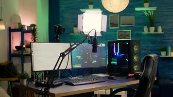 Empty streaming room with professional powerful computer, RGB keyboard and mouse, headphones and mirophone. Player talking with other players on streaming chat during online competition photo