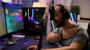 Winner streamer playing online space shooter game in gaming room using RGB keyboard and system desktop. Cyber performing on powerful pc talking with players on chat open during live competition photo