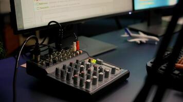 Close-up of streamer checking sound using professional mixer for streaming games in home studio late at night. Pro gamer playing space shooter games talking with team mates on open chat photo