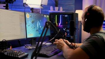 Streamer man winning space shooter game during esport tournament. Pro gamer using wireless controller, professional mouse and headset late at night in streaming home photo