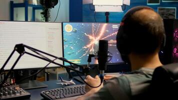 Streamer with headphone losing space shooter game competition using modern equipment. Player sitting on streaming chair use wireless console and talking with other players on streaming chat photo