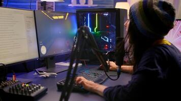 Streamer sitting on gaming chair and playing first person shooter game during online competition. Cyber performing on powerful computer in streaming room using professional RGB keypad photo