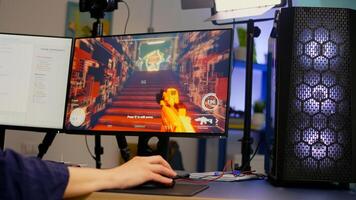 Close-up of streamer playing first person shooter game using RGB keyboard and mouse. Gamer talking on streaming chat with other players during esport tournament late at night in gaming studio photo