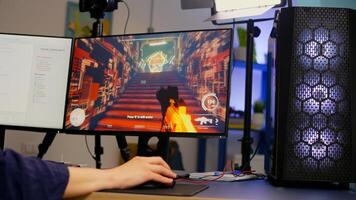 Close-up of streamer playing first person shooter game using RGB keyboard and mouse. Gamer talking on streaming chat with other players during esport tournament late at night in gaming studio photo