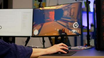 Close-up of pro streamer use RGB mouse during first person shooter game tournament. Gamer sitting on gaming chair during streaming competition in room with neon lights photo