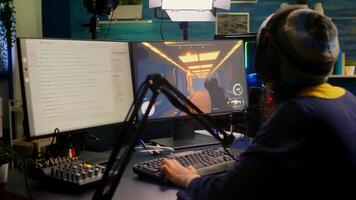 Pro streamer check sound on mixer and start playing first person shooter game during virtual competition. Gamer using professional streaming setup late at night in gaming home studio photo