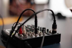 Closeup of professional recording instrument on desk. Audio mixer for live broadcast. Podcast electronic console in home studio. Broadcasting mixing desk station used to record sound and dubbing. photo