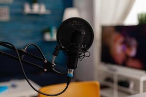 Closeup of recording microphone in home studio. Professional live broadcast equipment to record content on social media. Electronic audio livestream technology on desk. Podcast instrument. photo