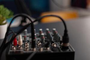 Closeup of professional recording equipment on desk. Audio mixer for live broadcast. Podcast electronic console in home studio. Broadcasting mixing desk station used to record sound and dubbing. photo