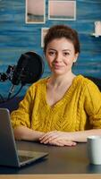 Portrait of young vlogger working in cozy studio, smiling at camera ready to start new podcast show. On-air online production internet broadcast show host streaming web content record digital blog photo