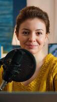 Woman blogger sitting in home studio looking at camera preapring for live recording podcast show. On-air online production internet broadcast host streaming web content record digital blog photo