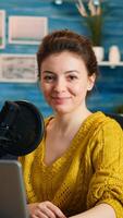 Portrait of vlogger looking at camera and smiling before starting live vlog, recording podcast. On-air online production internet broadcast show host streaming blog content from studio photo