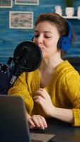 Famous blogger streaming from home studio putting headphones recording vlog. On-air online production internet broadcast show host streaming live content record digital social media communication photo
