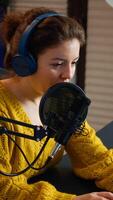 Blogger speaking at microphone with followers livestreaming typing on laptop. Online show On-air production internet broadcast host streaming live content, recording digital social media communication photo