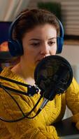 Internet show host answering at questions of fan texting on phone and talking at microphone from home podcast studio. Show production broadcast presenter streaming live content recording digital media photo