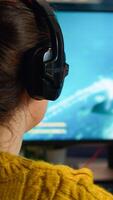 Back view of professional online gamer woman playing shooter game. Pro esport team player streamer playing gaming tournament on powerful RGB computer, using modern streaming technology photo