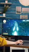 Professional gamer playing first-person shooter online game on powerful personal computer with colorful neon led lights. Cyber performing on pc in stylish room during gaming tournament photo