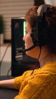 Professional esport woman gamer using mic of headset talking playing shooter game with team on streaming services. Virtual shooter game in cyberspace, esports player performing on pc gaming tournament photo
