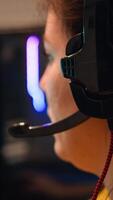 Close up of pro girl playing computer FPS shooter game on championship, talking into headset. Esport team of gamers play in mock-up videogame., performing in stylish cyber room. photo