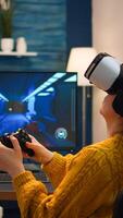 Professional gamer wearing virtual reality headset using wireless controller. Pro esport team player streamer playing gaming tournament on powerful RGB computer, using modern streaming technology photo