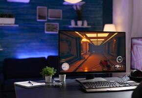 Nobody at desk with online games on computer to play with controller. Empty room with digital game on monitor, modern gaming equipment and device to have leisure activity. photo