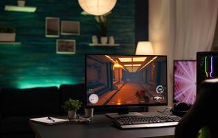 Empty room with online games on computer to play with controller. Nobody at desk with digital game on monitor, modern gaming equipment and device to have leisure activity. photo