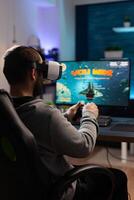 Person using controller and vr glasses, playing games. Man winning game while he uses joystick and virtual reality headset on computer. Gamer feeling happy about online win. photo