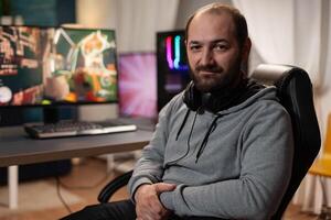 Portrait of man playing games on live stream, using computer and modern gaming equipment. Gamer live streaming gameplay, broadcasting game stream online. Person playing games photo