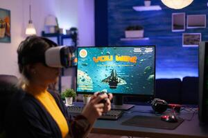 Person playing games with vr glasses on computer. Gamer using virtual reality headset and controller to play and win online game on monitor. Player with modern equipment at desk. photo