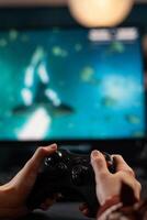 Close up of woman holding joystick and playing games on computer. Gamer using controller to play online digital games in front of monitor. Person with modern gaming equipment photo