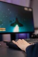 Close up of woman playing games on keyboard. Hand using computer console to play online digital games, having fun with electronic e sport in cyberspace. Player gaming on monitor photo