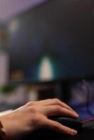Close up of woman using mousepad to play games on computer. Gamer playing digital game with mouse and pad in front of monitor to have fun. Player using online gaming equipment photo