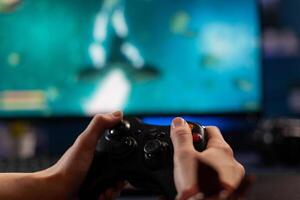 Close up of gamer holding controller and playing games on computer. Woman using joystick to play online digital games in front of monitor. Person with modern gaming equipment photo