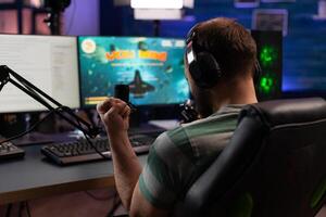 Person celebrating gameplay win with chat on live stream. Man streaming and playing games on computer with microphone and headset. Player winning game while he is live streaming. photo