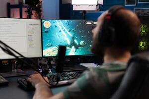 Man playing games on online stream with chat. Gamer using microphone and headset on computer, live streaming gameplay. Streamer broadcasting with gaming equipment in front of on monitor. photo