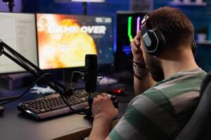 Person losing games on live stream with chat. Man using headphones and microphone to broadcast gameplay, streaming lost game on computer. Gamer playing online on social media. photo