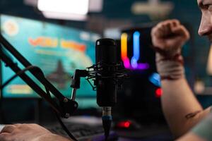 Close up of man winning games on stream with live chat, celebrating win and live streaming gameplay. Streamer using headphones and microphone on computer to broadcast and play. photo