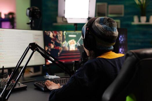 Gamer doing online live stream with games. Woman using gameplay on computer, streaming and looking at monitor with chat. Person broadcasting and playing games with microphone. photo