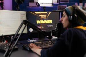 Adult winning games on online stream with live chat. Woman streaming gameplay on computer with hmicrophone and headphones. Person broadcasting while she plays game. photo