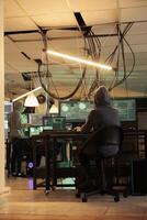 Phishing attack, hacker coding internet fraud program script, programming password cracking app on computer. Cyberattack, data breach, woman in hood developing malicious software at night time photo