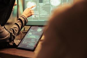 Hackers gettng access to important database online on computer network, planting virus to create malware. Team of spies working on cyberterrorism attack with online script codes. photo