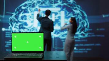 Startup coworkers using AI software on chroma key notebook to take data driven decisions. Close up of isolated screen laptop used for developing artificial intelligence solutions, camera B photo