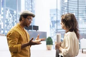 Client discussing with the real estate agent about architectural change and renovation, reviewing blueprints plans during office tour. Entrepreneur negotiating a leasing contract deal. photo