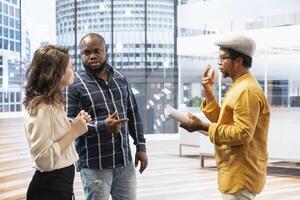 Clients and real estate agent visiting a space on an office tour, reviewing modern property layout and architectural plans. Business professionals discussing high class urban building investment. photo