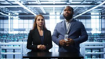 System administrators looking at holograms in data center, doing swiping motions hand gestures. Server farm workplace employees interacting with augmented reality tech, camera B photo